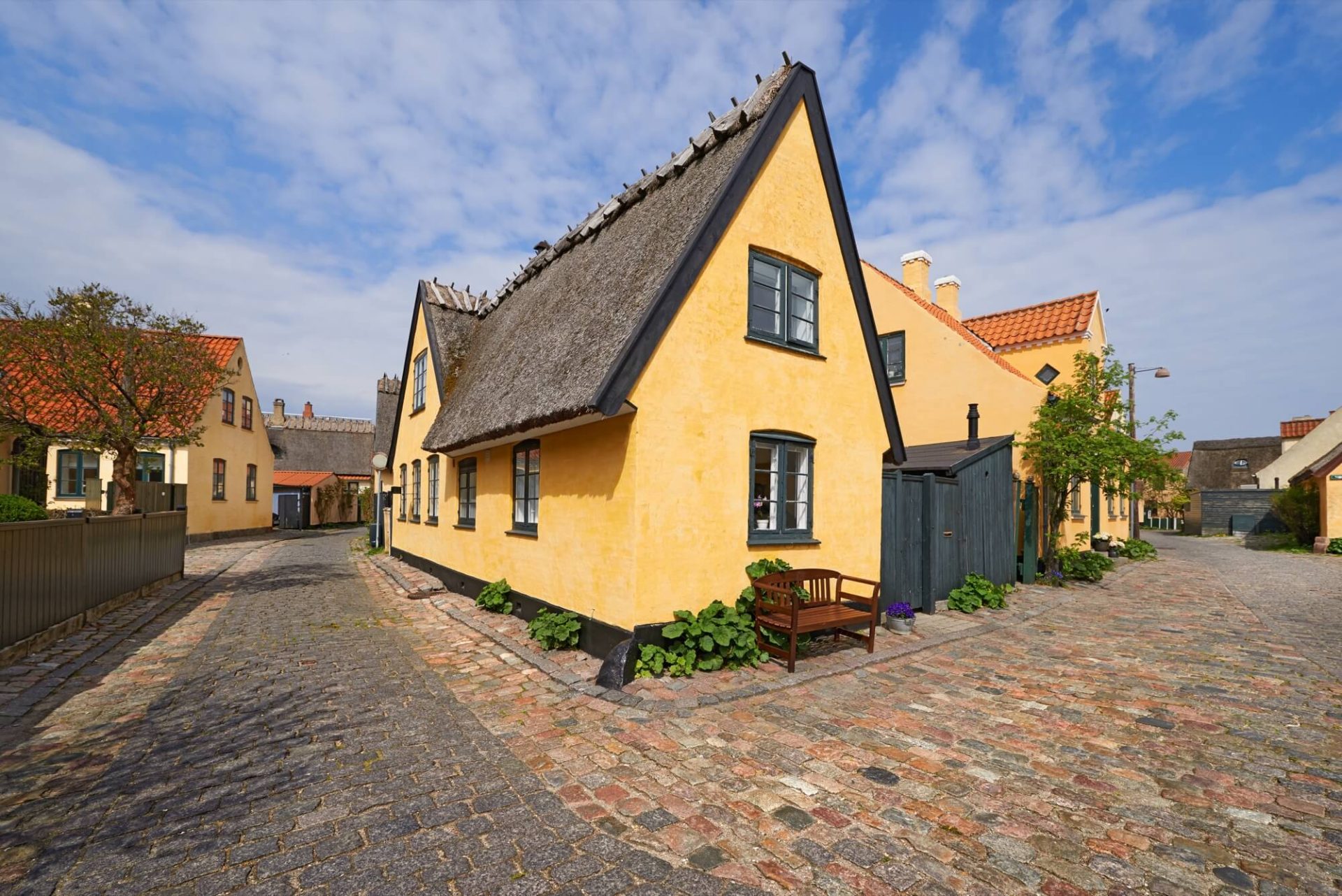 Den pittoreska gatan får sitt utseende från ett hus med en nyligen uppdaterad, gammaldags fasad i gult, svarta fönster och ett tak av strå